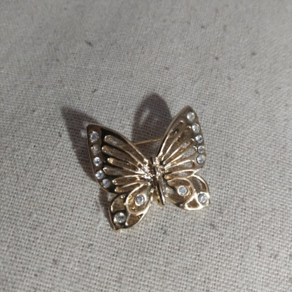 Butterfly gold tone brooch with rhinestones.